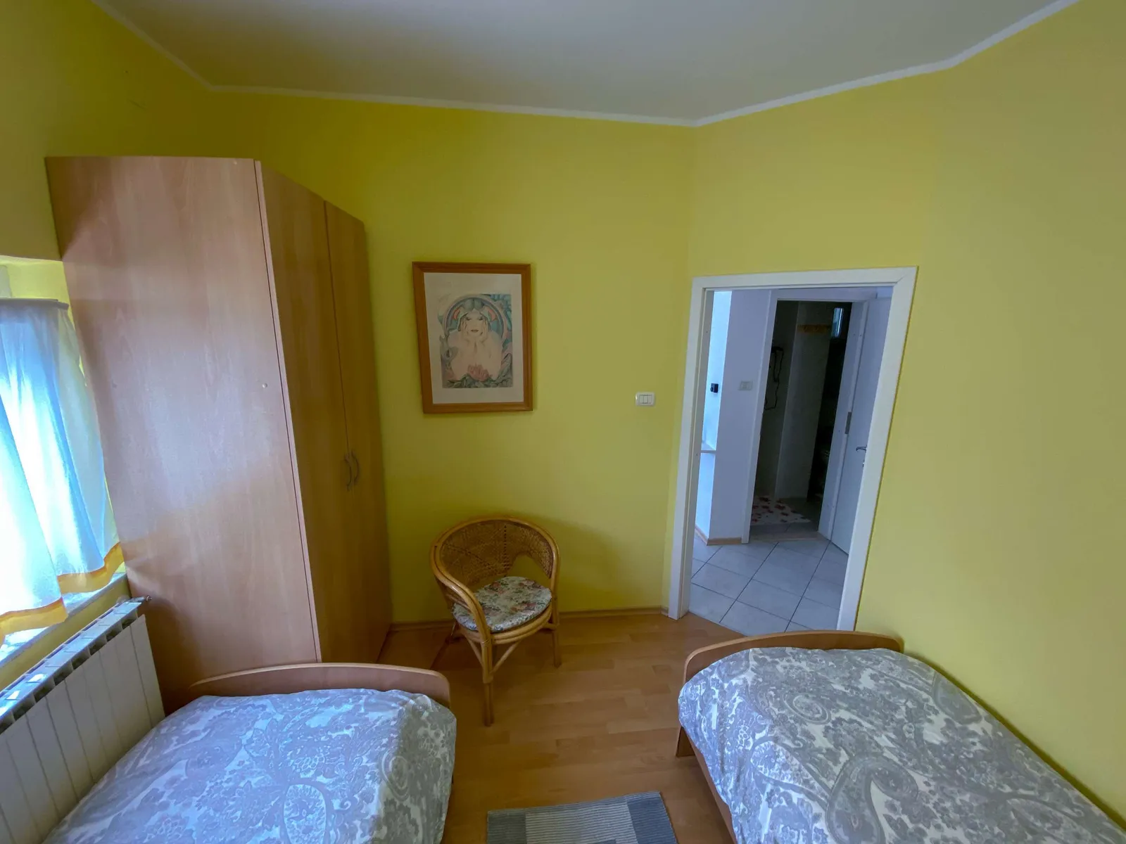 Druga spalnica z omaro in pletenim stolom